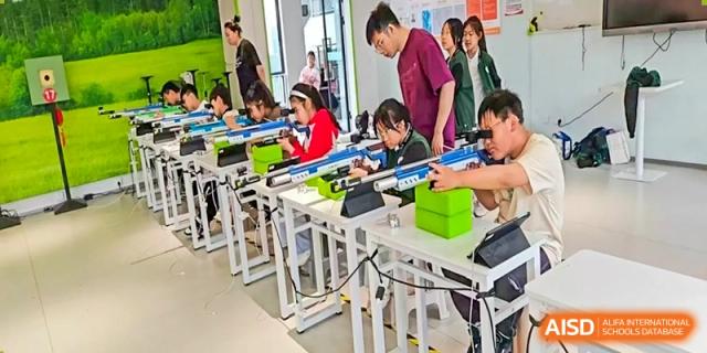 A classroom or workshop of Yancheng Foreign Language School students focused on assembling models or working with small components at individual white desks.