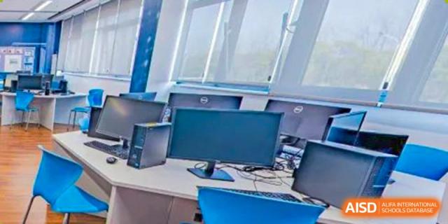A close-up view of a school desk with a computer monitor and keyboard, representing a learning station at ISA Wuhan International School.