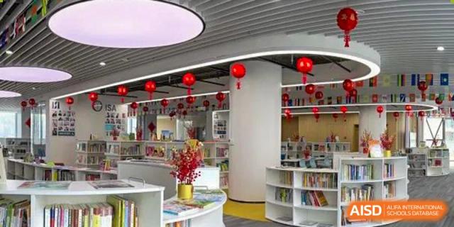 A bright, modern school library or lounge area decorated with red lanterns and plants at ISA Wuhan International School.
