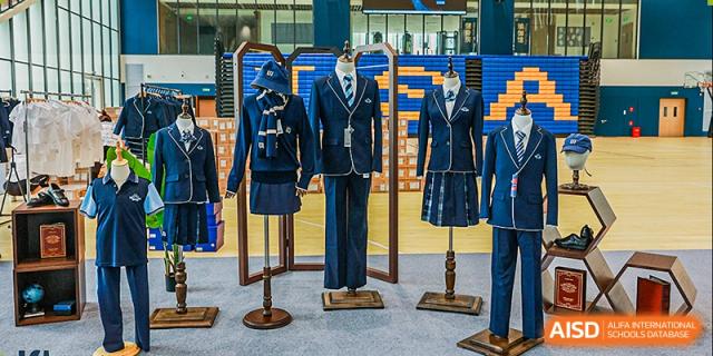 A display of the dark blue school uniforms, including blazers, trousers, and skirts, for ISA Wuhan International School.