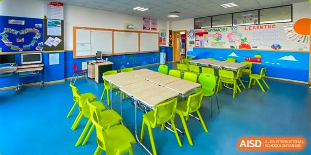 A brightly colored classroom or study space at Changwai Bilingual School with green and yellow chairs.