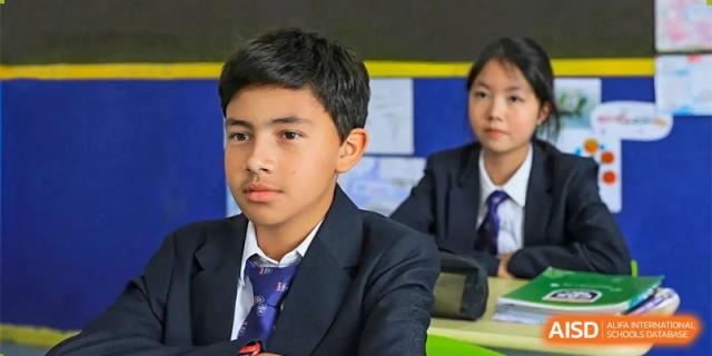 A student from Changwai Bilingual School sitting at his desk and looking forward during a class.