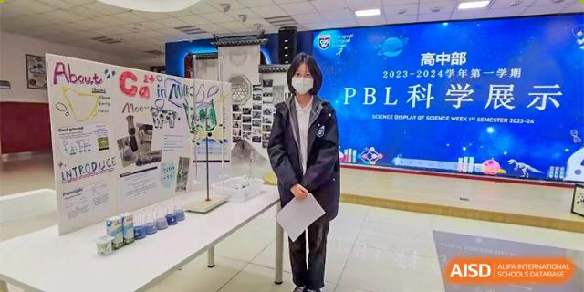 A teacher or staff member from Changwai Bilingual School holding a binder labeled "PBL."
