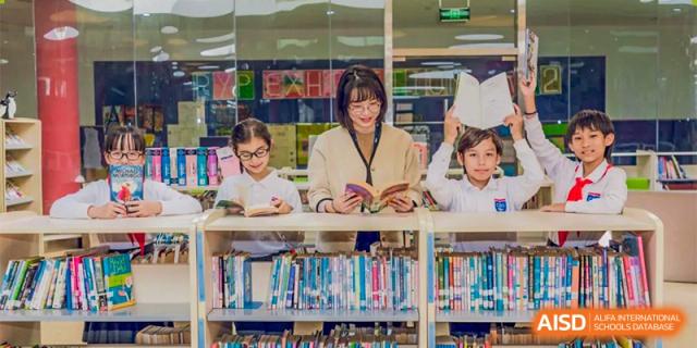 A teacher at Changwai Bilingual School reading to a group of young students in a library.