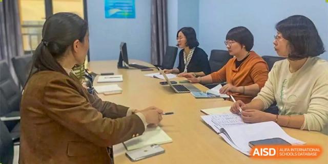 Staff or teachers from Changwai Bilingual School sitting at a table during a meeting.