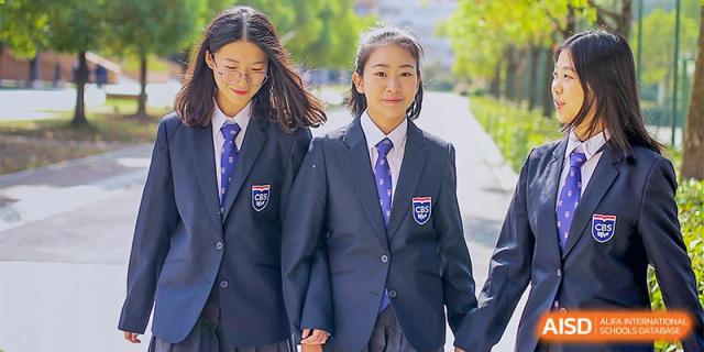 Two students from Changwai Bilingual School in their school uniforms, smiling for the camera.
