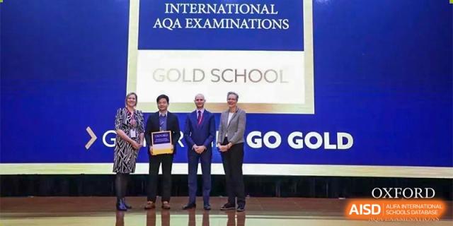 A group of teachers or staff from Changwai Bilingual School receiving an award for being an "International AQA Examinations Gold School."