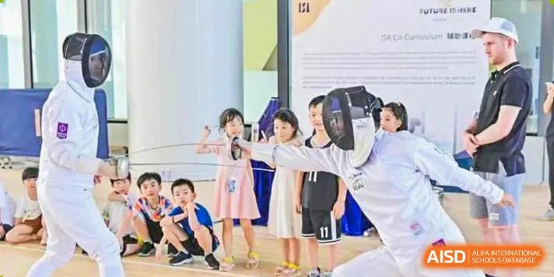 A group of young students standing together, some smiling and posing for a picture, at ISA Wuhan International School.