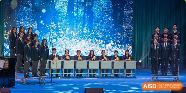 Changwai Bilingual School students watching performance, bright lights, stage, school event, engagement, audience, culture.