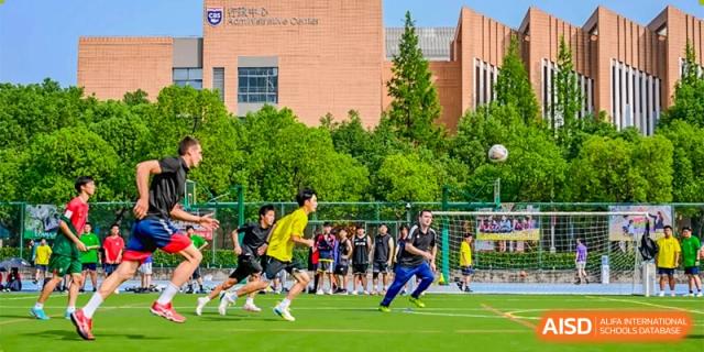Changwai Bilingual School students playing soccer on grassy field, football, team sport, outdoor activity, recreation.