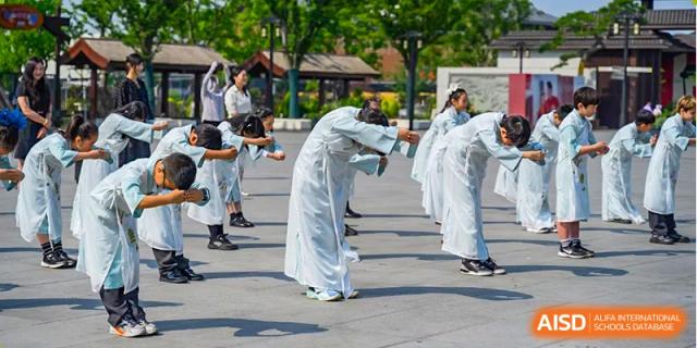 Students from Changwai Bilingual School participating in a traditional performance or activity outdoors.