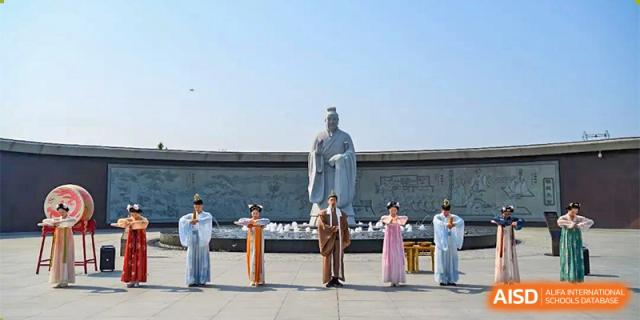 A group of students from Changwai Bilingual School gathered near a statue on a field trip.