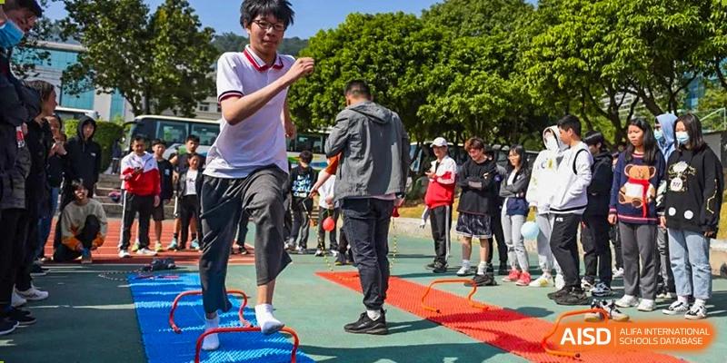 Male students from Fuyuan British American School participating in an outdoor physical activity or game on the campus grounds.