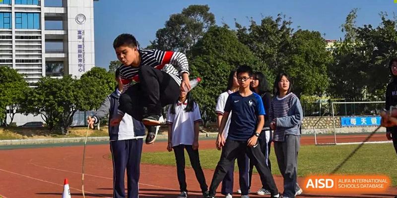 A group of students from Fuyuan British American School standing outside on the campus grounds during a school day.