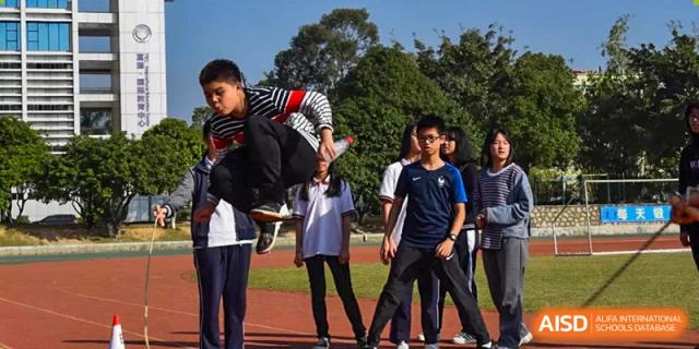 A group of students from Fuyuan British American School standing outside on the campus grounds during a school day.