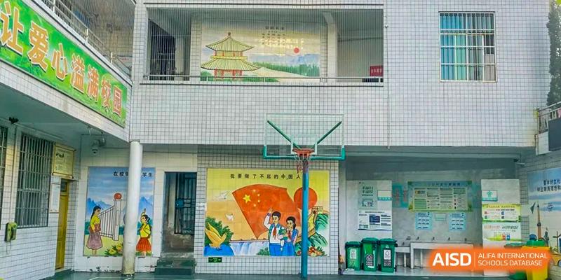 An outdoor basketball court at Fuyuan British American School with a mural and decorative wall art featuring Chinese characters.
