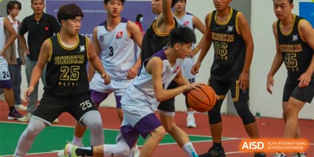 Basketball players from Fuyuan British American School dribbling the ball and competing during an intense game.