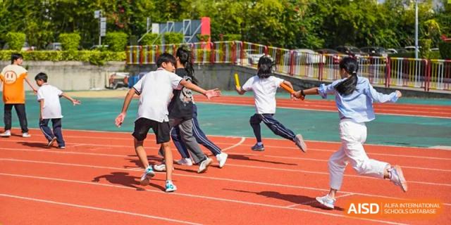 Students from Fuyuan British American School playing a running game or physical activity on an outdoor track.