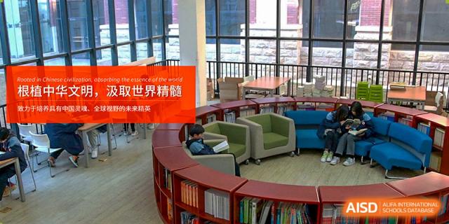 A student sitting in a comfortable armchair, reading a book in the brightly lit, circular seating area of the library at Glocal Elite International School.