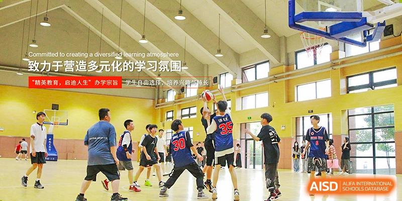 A group of students playing basketball on an indoor court, framed by a poster encouraging a good learning atmosphere at Glocal Elite International School.
