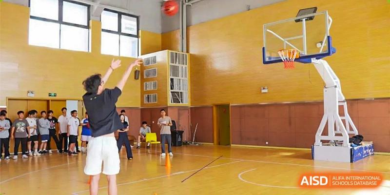 An image of the bright, wooden floor indoor gymnasium where students are practicing basketball at Glocal Elite International School.