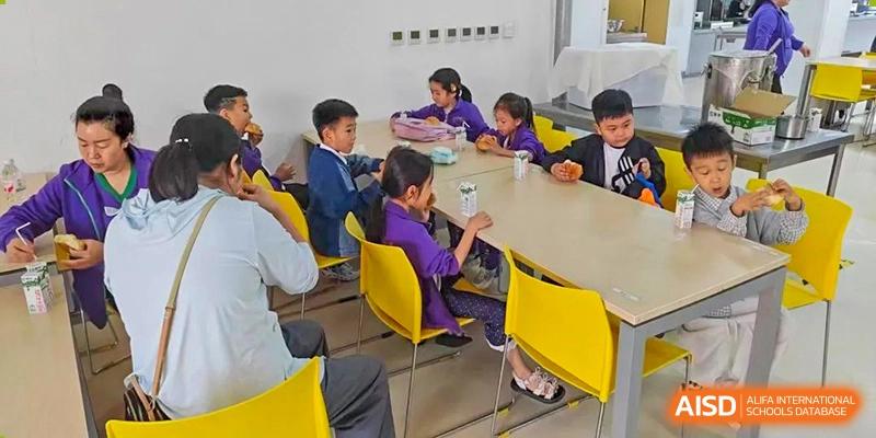 A small group of students sitting around a table in a bright classroom, studying or collaborating on a project at Glocal Elite International School.