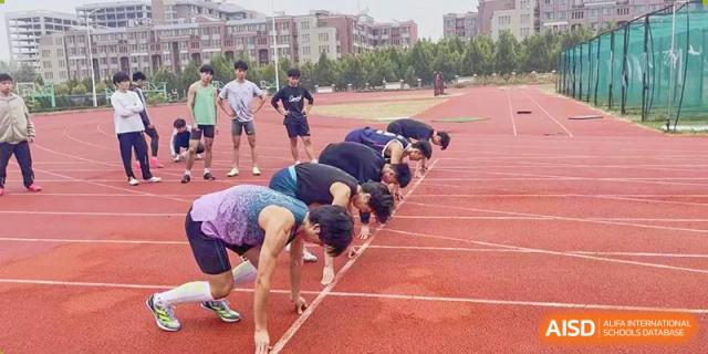 Students crouched down at the starting line on a red track, ready for a running event at Glocal Elite International School.