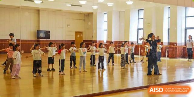 A line of students facing forward, concentrating on a group physical activity or performance inside the school facility at Glocal Elite International School.