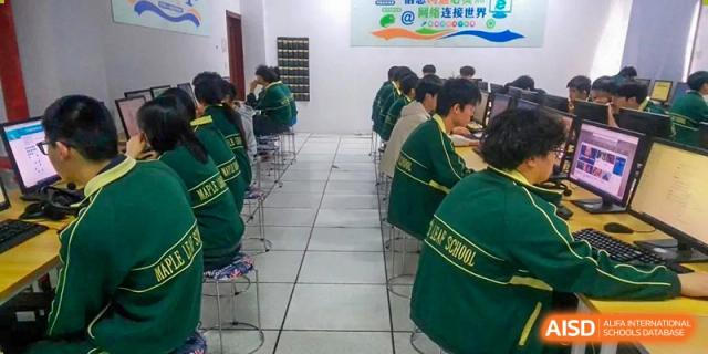A long view of students seated at desks in an orderly classroom setting, all wearing green uniforms, at Maple Leaf International School-Zhenjiang.