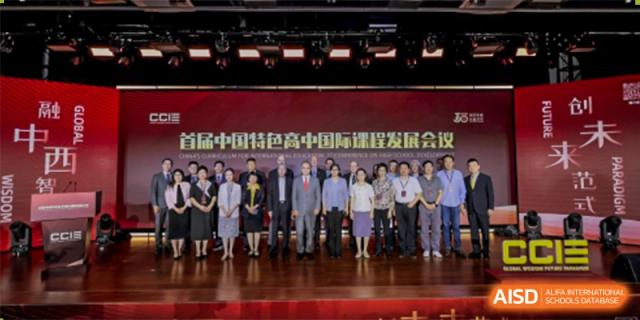 A large group of staff, administrators, and guests posing for a photo at a professional event at Maple Leaf International School-Zhenjiang.