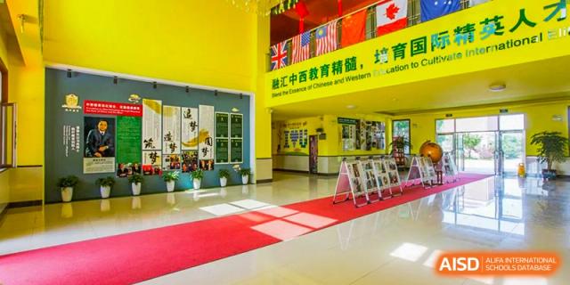 The bright, colorful interior entrance hall of a school building with a red carpet at Maple Leaf International School-Zhenjiang.