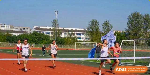 A student running a race on an outdoor track and field at Maple Leaf International School-Zhenjiang.