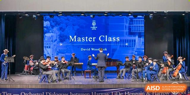 Students performing on stage with a piano and a conductor during a music Master Class at Harrow LiDe School Hengqin.