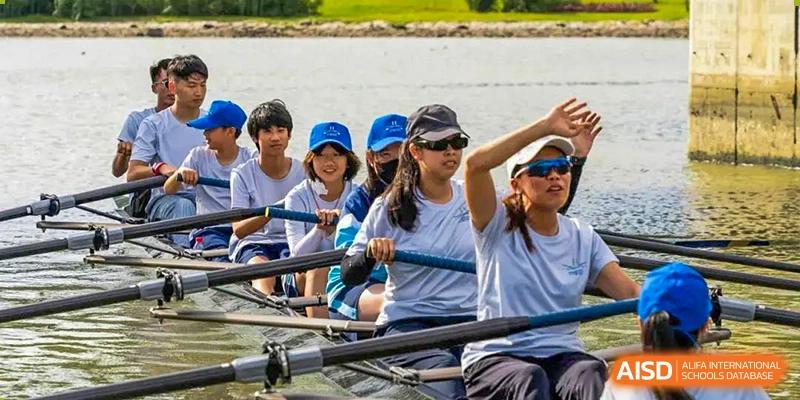 Students and a female instructor rowing together in an outdoor water activity as part of the Harrow LiDe School Hengqin program.