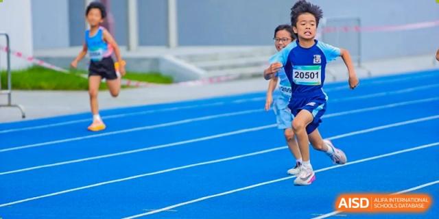 Young students from Harrow LiDe School Hengqin run on the blue track during an athletics or sports event.