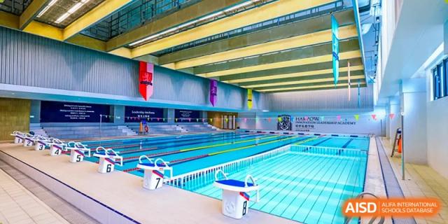 Interior wide view of the well-lit, multi-lane indoor swimming pool complex at Harrow LiDe School Hengqin.
