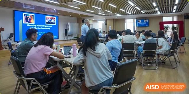 Students working together on laptops and papers in a classroom at the High School Affiliated to Shanghai Jiao Tong University.