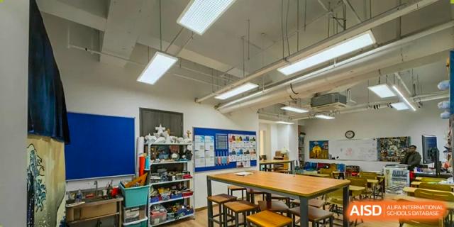An empty classroom with tables, stools, and shelves full of lab equipment and supplies at the High School Affiliated to Shanghai Jiao Tong University.