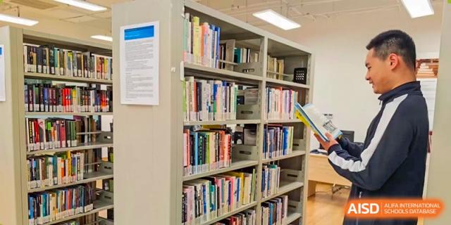 A close-up of a shelf with various books in the school library at the High School Affiliated to Shanghai Jiao Tong University.