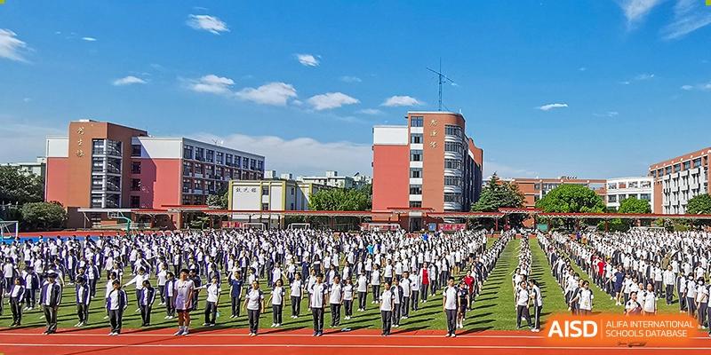 Students in uniform doing an outdoor group activity on a track at the High School Affiliated to Shanghai Jiao Tong University.