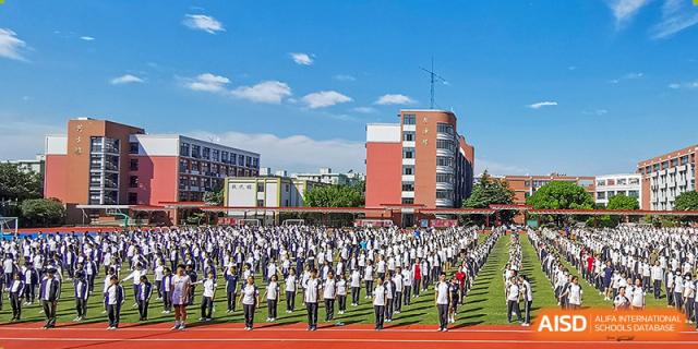 Students in uniform doing an outdoor group activity on a track at the High School Affiliated to Shanghai Jiao Tong University.