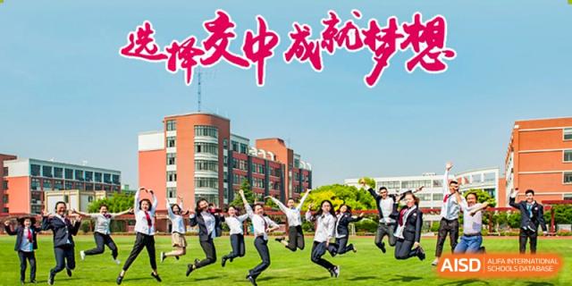 A group of students in uniform jumping in the air in front of a school building with a large sign at the High School Affiliated to Shanghai Jiao Tong University.