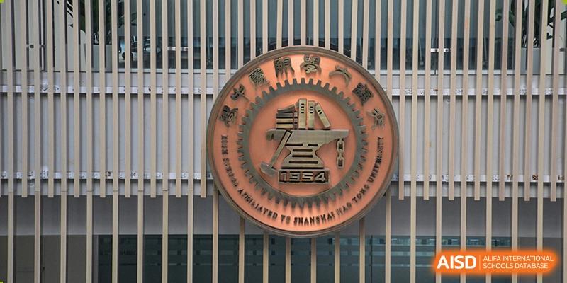 A close-up shot of the school's official circular emblem, featuring gears and a star at the High School Affiliated to Shanghai Jiao Tong University.