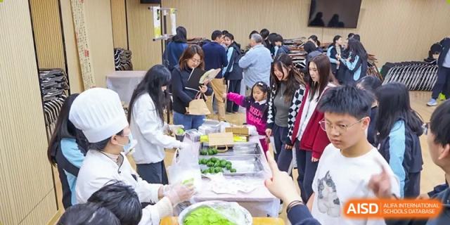 Students and staff at a busy food preparation event at the High School Affiliated to Shanghai Jiao Tong University.