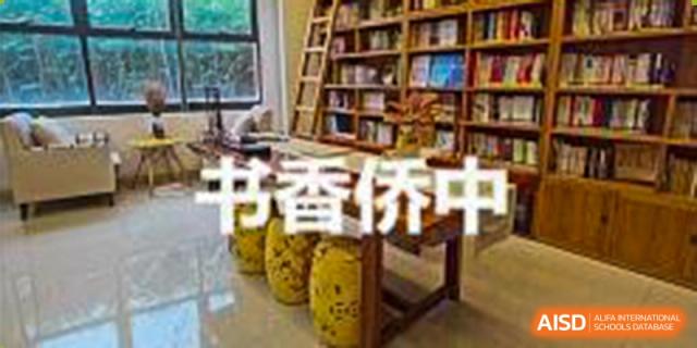 A reading nook or library section with books, stools, and the Chinese characters "书香伴我" at the Guangdong Overseas Chinese High School International Curriculum.