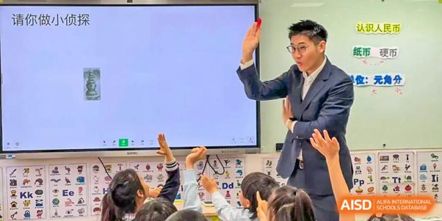 A teacher at Wahaha Bilingual School Hangzhou is giving a demonstration to students in a science class.
