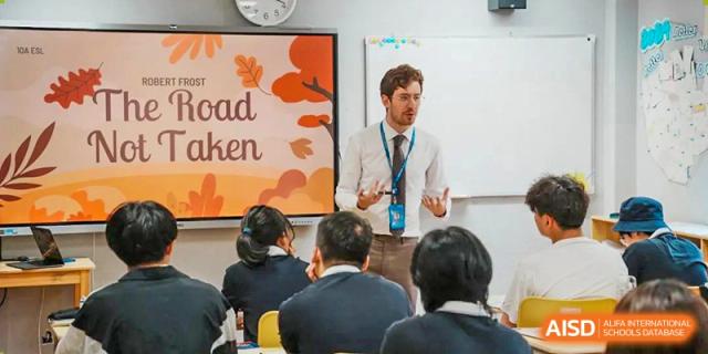 A teacher is giving a lecture to a group of students in a classroom at Wahaha Bilingual School Hangzhou.