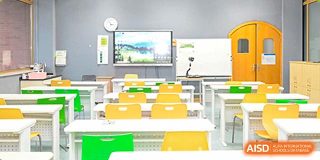 An empty classroom with bright yellow chairs and a large screen at Wahaha Bilingual School Hangzhou.