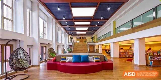 A modern, comfortable lounge area with sofas and a view of a city at Wahaha Bilingual School Hangzhou.