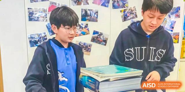 A student from Shanghai United International School Hefei Campus sharing their work with another student.